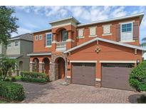Charming two-story home features a brick driveway, a two-car garage, and manicured landscaping at 341 Lasso Dr, Kissimmee, FL 34747