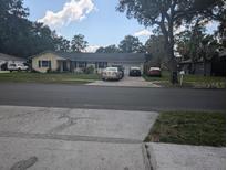 Ranch-style home with a two-car garage and mature trees at 4345 Old Colony Rd, Mulberry, FL 33860