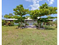 Charming single-story home featuring a light-blue facade, covered porch, lush landscaping, and mature trees in the front yard at 4730 Cypress Creek Ranch Rd, St Cloud, FL 34771