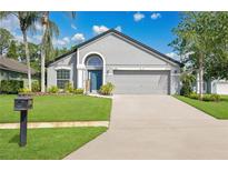 Charming home featuring a well-manicured lawn, attached garage, and inviting front entrance at 501 Dunoon St, Ocoee, FL 34761