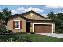 Charming single-story home with a two-car garage, lush landscaping, and a well-manicured lawn at 5135 Kinsley Dr, Lake Wales,, FL 33859