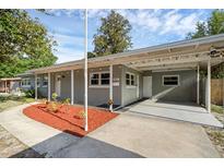 Charming single-story home featuring a covered carport, manicured landscaping, and a freshly painted facade at 807 E Airport Blvd, Sanford, FL 32773