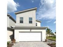 Modern two-story home featuring a two-car garage and contemporary architectural design under a bright blue sky at 921 Spring Palms Loop, Orlando, FL 32828