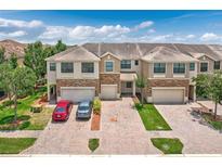 Well-maintained townhome exterior with brick driveway, two car garage, and manicured landscaping at 1628 Portofino Meadows Blvd, Orlando, FL 32824