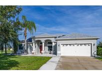 Charming single-story home with a well-manicured lawn, palm tree, and a two-car garage at 1760 Boat Launch Rd, Kissimmee, FL 34746