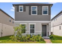 Charming two-story home featuring neutral gray siding, decorative shutters, and manicured front garden at 4736 Homestead Trl, St Cloud, FL 34772