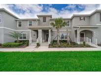 Charming townhome featuring well-maintained landscaping, gray facade, and inviting front porches at 4903 Windermere Ave, Kissimmee, FL 34746