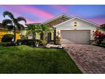 Charming single Gathering home featuring stone accents, paver driveway, a well-manicured lawn and lush landscaping at 582 San Joaquin Rd, Kissimmee, FL 34759
