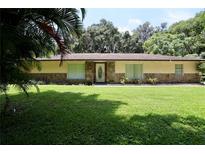 Charming single story home with a stone facade and a large, well-manicured front yard at 860 Oak Shore Dr, St Cloud, FL 34771
