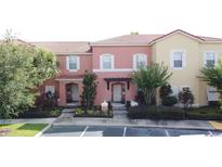 Charming townhouses featuring colorful facades, tile roofs, and lush landscaping in a vibrant community at 109 Pompano Beach Dr, Kissimmee, FL 34746