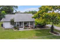 Charming single-story home featuring a well-manicured lawn, inviting porch, and mature landscaping at 1640 Marks St, Kissimmee, FL 34746