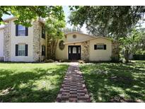Charming two-story home with stone accents and mature trees, creating a welcoming curb appeal at 1843 Harbor Blvd, Kissimmee, FL 34744