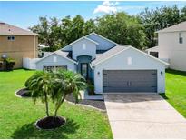 Charming single Gathering home featuring a well-manicured lawn and an attached two-car garage at 1851 Hammock Moss Dr, Orlando, FL 32820