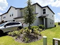 Inviting two-story home showcasing tasteful landscaping and a well-maintained lawn at 2086 Crape Jasmine Ln, Orlando, FL 32824