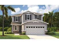 Charming two-story home with gray siding, stone accents, a well-manicured lawn, and a two-car garage at 223 Bull Frog Ln, Umatilla, FL 32784