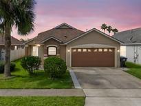 Charming single-Gathering home with a well-manicured lawn, lush landscaping, and a two-car garage at 2912 Lazlo Ln, Orlando, FL 32837