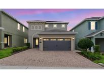 Charming home with a two-car garage, brick driveway, and manicured landscaping at 340 Pendant Ct, Kissimmee, FL 34747