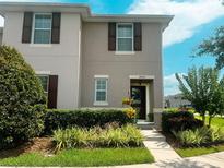 Inviting two-story townhome featuring manicured landscaping and a welcoming entrance at 4800 Riverwalk Dr, St Cloud, FL 34771