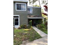 Two-story townhouse with a walkway, patio, and lush landscaping surrounding the front entrance at 5826 Peregrine Ave # F01, Orlando, FL 32819