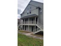 Two-story building featuring covered balconies and exterior staircases, set against a partly cloudy sky at 6148 Westgate Dr # 302, Orlando, FL 32835