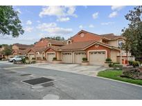 Row of townhomes featuring terra cotta color, tile roofs, and two car garages at 7667 Sugar Bend Dr # 7667, Orlando, FL 32819