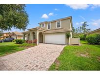 Charming two-story home with a tile roof, paver driveway, and inviting front porch at 9128 Stromboli Ct, Kissimmee, FL 34747