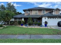 Well-maintained two-story home featuring a landscaped front yard and a two-car garage at 11922 Ottawa Ave, Orlando, FL 32837