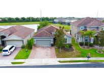 Beautiful single-Gathering home features a clay tile roof, brick driveway, and well-manicured lawn at 2016 Lakeside Ave, Davenport, FL 33837