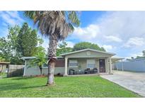 Charming single-story home featuring a well-manicured front yard and covered porch with seating at 4520 W Oak Ridge Rd, Orlando, FL 32809