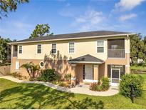 Charming two-story home with landscaped yard and screened-in porch under blue sky at 4899 Meadow Dr, St Cloud, FL 34772