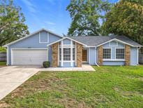 Charming single-story home featuring blue siding, brick accents, and a well-maintained front lawn at 5452 Higgins Way, Orlando, FL 32808