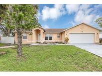 Charming single-story home with a well-manicured lawn and attached two car garage at 600 Regency Way, Kissimmee, FL 34758