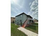 Two-story apartment building with exterior stairs, balcony, and tidy landscaping at 702 Michigan Ct # 4, St Cloud, FL 34769