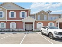 Inviting townhome exterior with guest parking and a well maintained landscaped entry at 7554 Sunflower Cir, Kissimmee, FL 34747