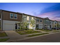 Charming townhomes with colorful facades and well-manicured landscaping on a peaceful street at 955 Grandin St, Davenport, FL 33837