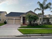 Charming single-Gathering home with well-maintained landscaping, lush lawn, and mature palm trees at 9721 Old Patina Way, Orlando, FL 32832