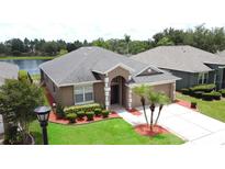 Well-maintained single Gathering home featuring a lush lawn, landscape beds, and inviting entryway at 9824 Secret Cove Ln, Orlando, FL 32832
