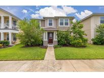 Charming two-story home with green lawn, landscaped shrubs, and light tan exterior paint at 11844 Founders St, Orlando, FL 32832