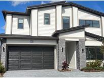 Two story home featuring a two car garage, neutral color palette, and stone facade at 1290 Butterfly, Davenport, FL 33837
