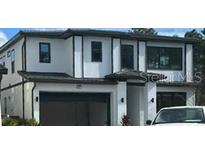 Modern two-story home with a two-car garage and sleek, dark window trim accents at 1327 Butterfly, Davenport, FL 33837