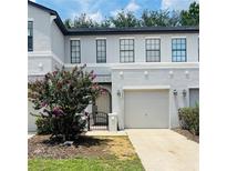 Charming townhome with a well-manicured lawn, blooming tree, and one-car garage at 2242 Seven Oaks Dr, St Cloud, FL 34772