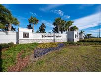 Harmony West community entrance sign surrounded by lush landscaping and palm trees at 2726 Harmonia Hammock Rd, Harmony, FL 34773