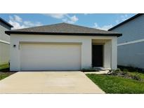 Charming single-Gathering home with a spacious two-car garage and well-manicured lawn on a sunny day at 2860 Poppy Avenue, Haines City, FL 33844