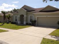 Charming single-story home featuring an attached two-car garage and well-maintained landscaping at 3074 Bay Laurel N Cir, Kissimmee, FL 34744