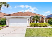 Charming home featuring a clay tile roof, well-maintained landscaping, and a two-car garage at 423 Paloma Dr, Davenport, FL 33837