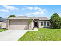 Charming single-story home with a well-manicured lawn and attached two-car garage at 440 Peppermill Cir, Kissimmee, FL 34758