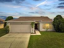 Charming single-story home with a two-car garage, well-maintained lawn, and inviting entrance at 440 Peppermill Cir, Kissimmee, FL 34758