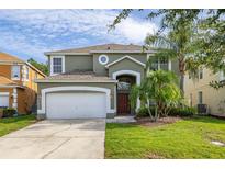 Charming two-story home featuring a two-car garage, arched entry, and lush landscaping at 4697 Golden Beach Ct, Kissimmee, FL 34746