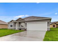Charming one-story home with a two-car garage, fresh green lawn, and neutral color palette at 515 Everest Way, Kissimmee, FL 34758