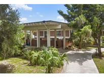 Modern brick home with an expansive covered entrance, lush landscaping and a charming walkway at 550 Lake Otis Se Dr, Winter Haven, FL 33880